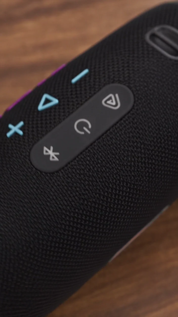 Gros plan sur les commandes et le revêtement tissé noir d’une enceinte JBL.