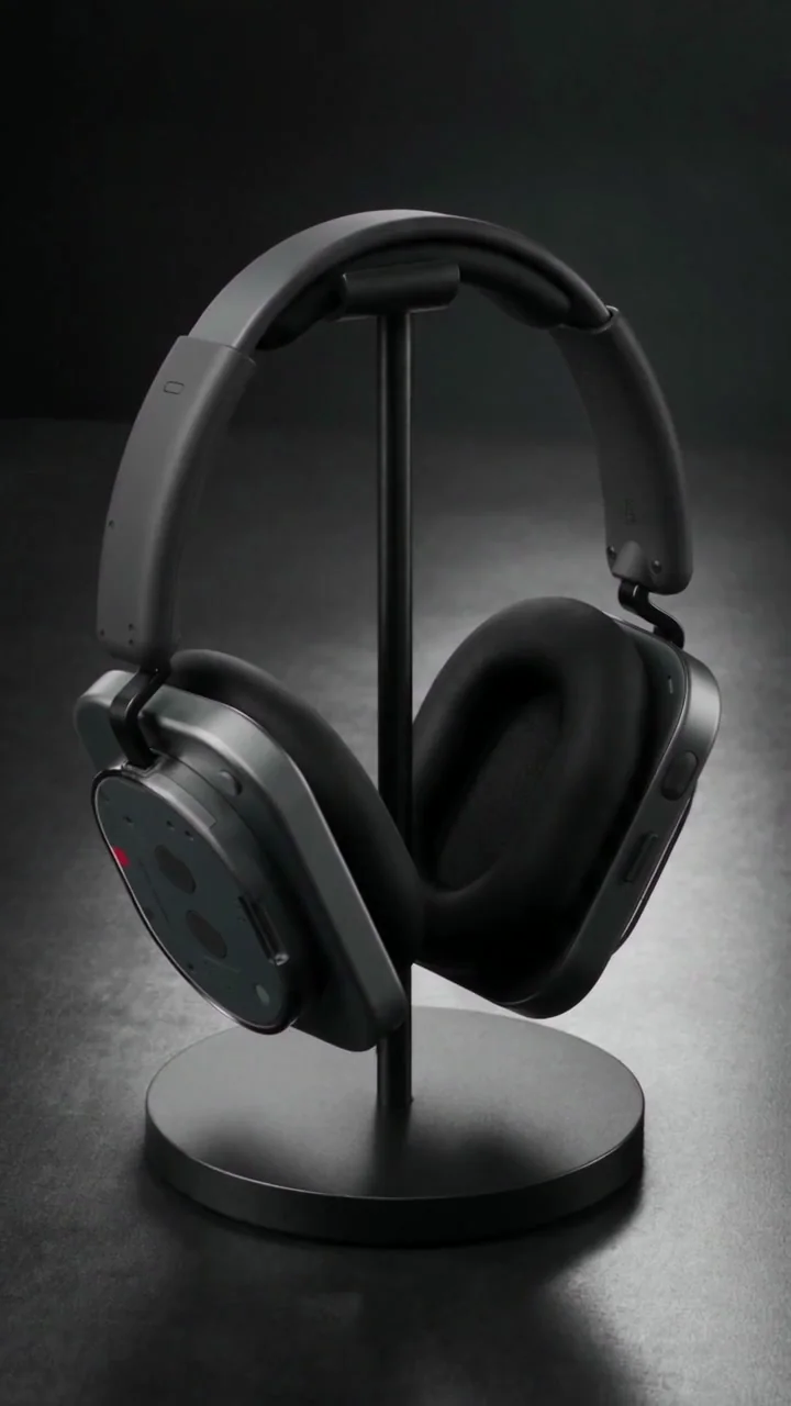 Casque Nothing noir suspendu à un support de table, avec les deux coussinets et l’arceau visibles.